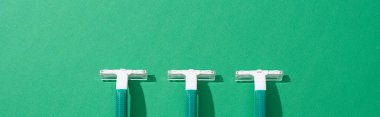 flat lay with green disposable razors on green background, panoramic shot clipart