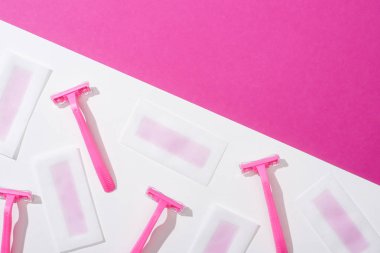 top view of disposable razors and wax depilation stripes on white and pink background clipart