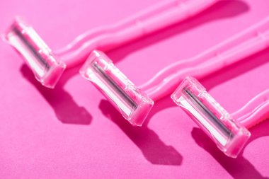 Pembe arkaplandaki tek kullanımlık tıraş bıçaklarının görüntüsünü kapat