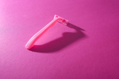 Pembe arkaplanda fotokopi alanı olan tek kullanımlık kadın jileti