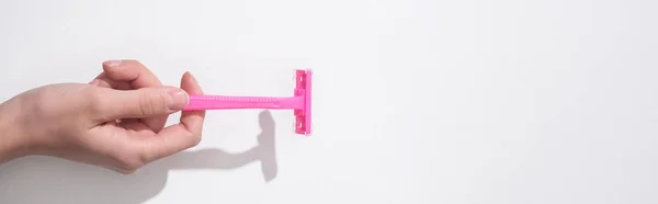 白い背景にピンクのかみそりを持つ女性のクロップドビュー パノラマショット — ストック写真