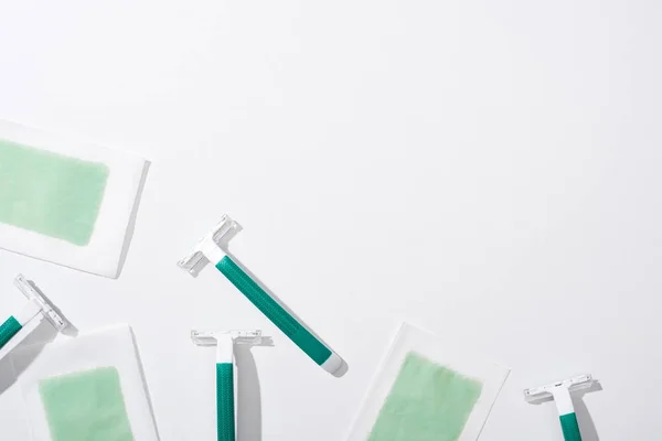白い背景に緑色のカミソリと剥離ワックスの縞模様のトップビュー — ストック写真