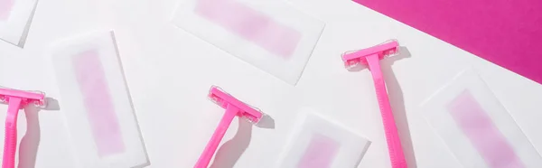 使い捨てのカミソリとワックスの剥離縞を白とピンクの背景でトップビューパノラマショット — ストック写真