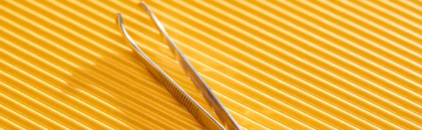 Stainless Steel Tweezers Yellow Textured Background Panoramic Shot — Stock Photo, Image