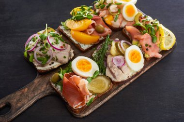Çavdar ekmeğinin seçici odak noktası gri yüzeyde Danimarka usulü smorrebrod sandviçler. 