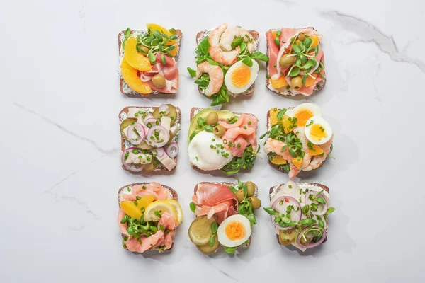 Bovenaanzicht Van Smakelijke Smorrebrod Sandwiches Wit Marmeren Oppervlak — Stockfoto