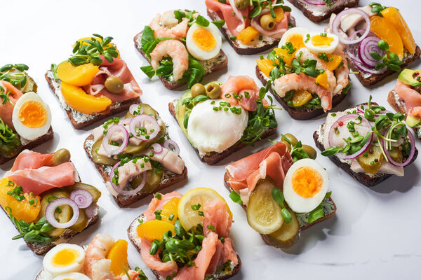 danish smorrebrod sandwiches on white marble surface 