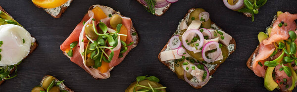 panoramic shot of danish smorrebrod sandwiches with herring fish and salmon on grey  surface 