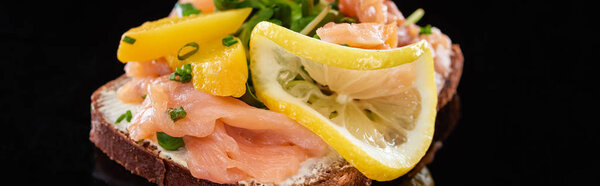 panoramic shot of delicious salmon on smorrebrod sandwich on black 