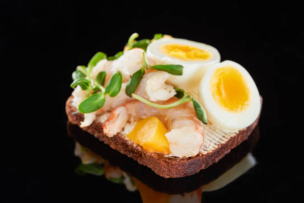 close up of rye bread with shrimps on smorrebrod sandwich on black 