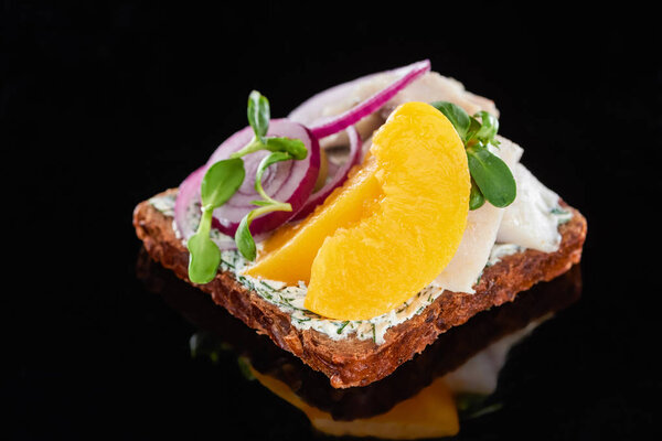 крупным планом селедки и консервированных персиков на вкусном датском сэндвиче Смореброд на черном
 