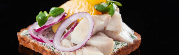 panoramic shot of herring fish on fresh smorrebrod sandwich on black 