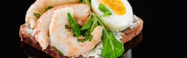 panoramic shot of boiled egg near shrimps on delicious danish smorrebrod sandwich on black 