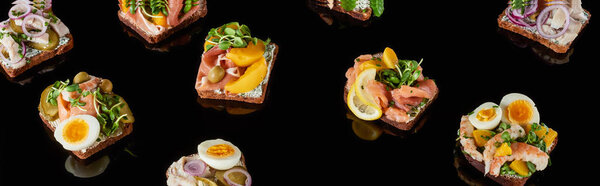 panoramic shot of rye bread with tasty danish smorrebrod sandwiches on black 