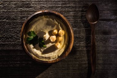Tahta kırsal masada nohutlu lezzetli humus manzarası.