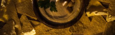 Nachos 'un yanında nohutlu lezzetli humus manzarası, panoramik çekim.