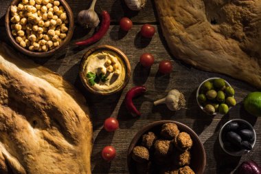 Tahta kırlarda nefis falafel, humus, nohut, pide, sebze ve zeytin manzarası.