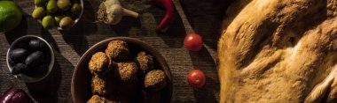 Tahta kırsal masada nefis falafel, humus, pide, sebze ve zeytin manzarası, panoramik çekim.