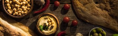 Lezzetli humus, nohut, pide, sebze ve zeytinler ahşap kırsal masada, panoramik çekim