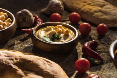 Lezzetli humus, nohut, pide, sebze ve baharatlar ahşap kırsal masada.