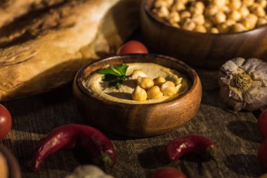 Lezzetli humus, nohut, pide, sebze ve baharatların seçici odağı ahşap kırsal masada.