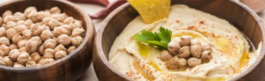 delicious hummus with chickpeas and nacho in bowls, panoramic shot clipart