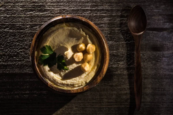 Draufsicht Auf Köstlichen Hummus Mit Kichererbsen Schale Auf Rustikalem Holztisch — Stockfoto