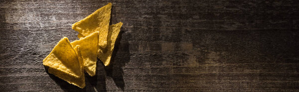 top view of delicious crispy corn nachos on wooden rustic table, panoramic shot