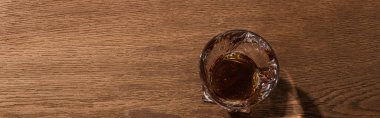 Top view of brandy in glass on wooden table, panoramic shot clipart