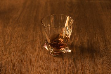 Glass of brandy on wooden table clipart