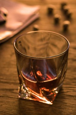 Selective focus of glass of brandy on wooden table clipart
