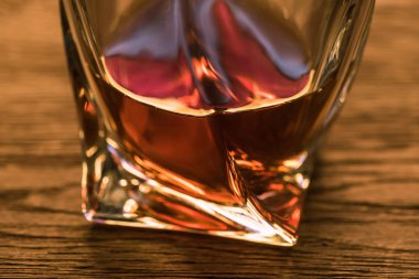 Brandy 'nin ahşap masadaki camdaki görüntüsünü kapat.