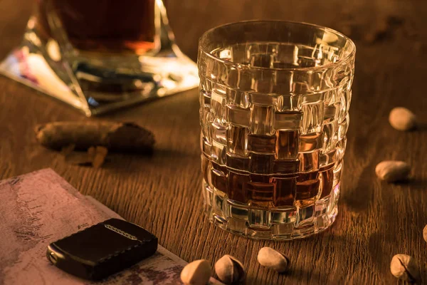 Glas Brandy Met Aansteker Kaart Pistachenoten Sigaar Houten Tafel — Stockfoto