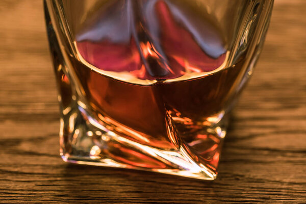 Close up view of brandy in glass on wooden table