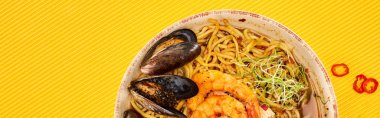 top view of seafood ramen on yellow surface, panoramic shot clipart