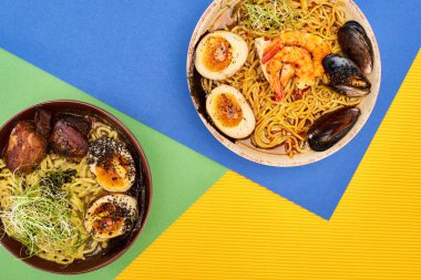 Çok renkli yüzeyde baharatlı deniz ürünleri ve etli ramen manzarası