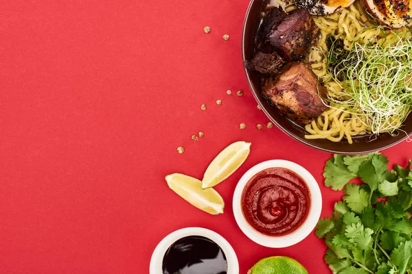 Top View Spicy Meat Ramen Sauces Parsley Lime Isolated Red — Stock Photo, Image