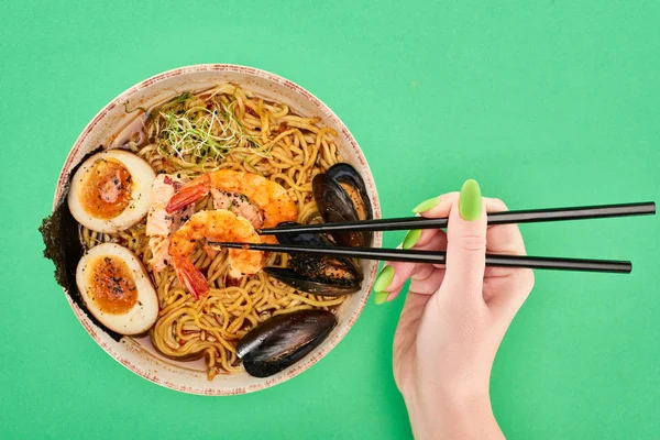 Cropped View Woman Eating Spicy Seafood Ramen Chopsticks Green Surface — Stock Photo, Image