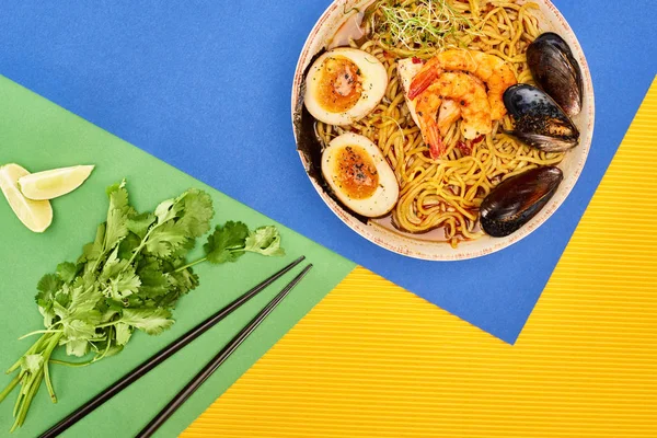 Top view of spicy seafood ramen near fresh ingredients and chopsticks on multicolored surface — Stock Image Top View Spicy Seafood Ramen Fresh Ingredients Chopsticks Multicolored Surface Stock Image