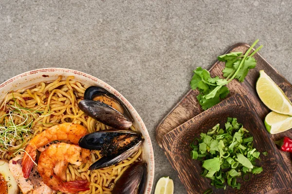 Top view of spicy seafood ramen near fresh ingredients on grey surface — Stock Image Top View Spicy Seafood Ramen Fresh Ingredients Grey Surface Stock Picture