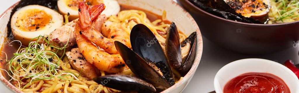 Spicy seafood and meat ramen in bowl on white surface near ketchup, panoramic shot — Stock Image Spicy Seafood Meat Ramen Bowl White Surface Ketchup Panoramic Shot Stock Image