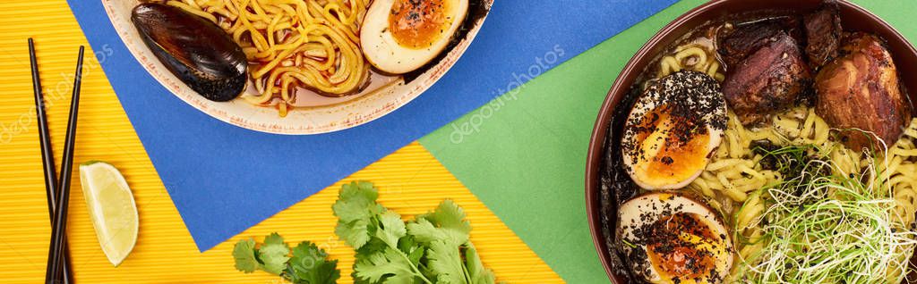 Top view of spicy seafood and meat ramen near fresh ingredients and chopsticks on multicolored surface, panoramic shot — Stock Image Top View Spicy Seafood Meat Ramen Fresh Ingredients Chopsticks Multicolored Stock Image