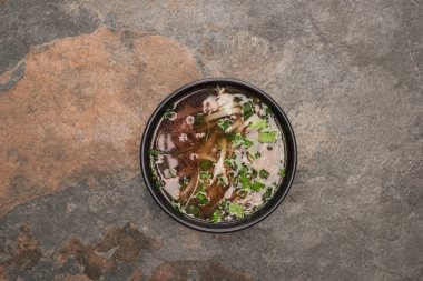 top view of pho in bowl on stone background clipart