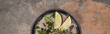 top view of pho in bowl with lime and coriander on stone background, panoramic shot clipart