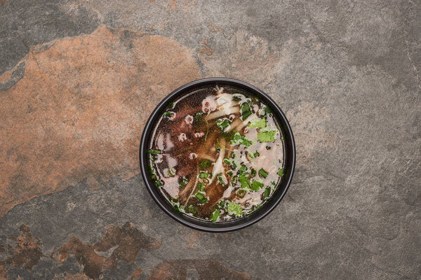 top view of pho in bowl on stone background