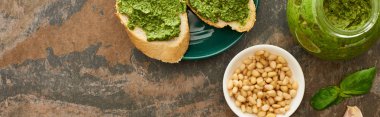 Tabakta pesto soslu baget dilimlerinin üst görüntüsü taş yüzeyinde taze malzemeler, panoramik çekim