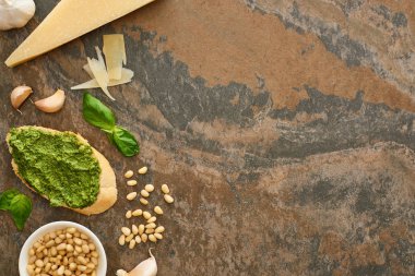 Taze malzemelerin yanında pesto soslu baget diliminin en üst görüntüsü.
