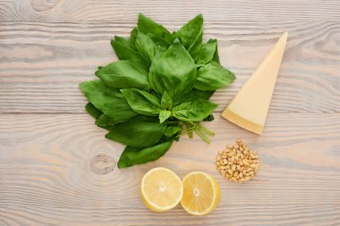 Ahşap masada pesto sosu malzemelerinin üst görüntüsü.