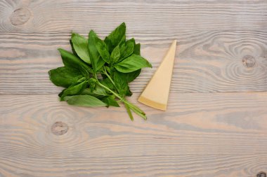 Ahşap masada pesto sosu malzemelerinin üst görüntüsü.