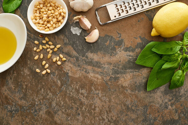 top view of pesto sauce ingredients and grater on stone surface